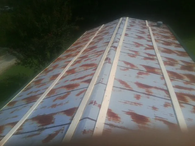 Rusted metal roof panels with new wood purlins before replacement — Storm Damage Roof Repair in Madill by Roofing Brothers
