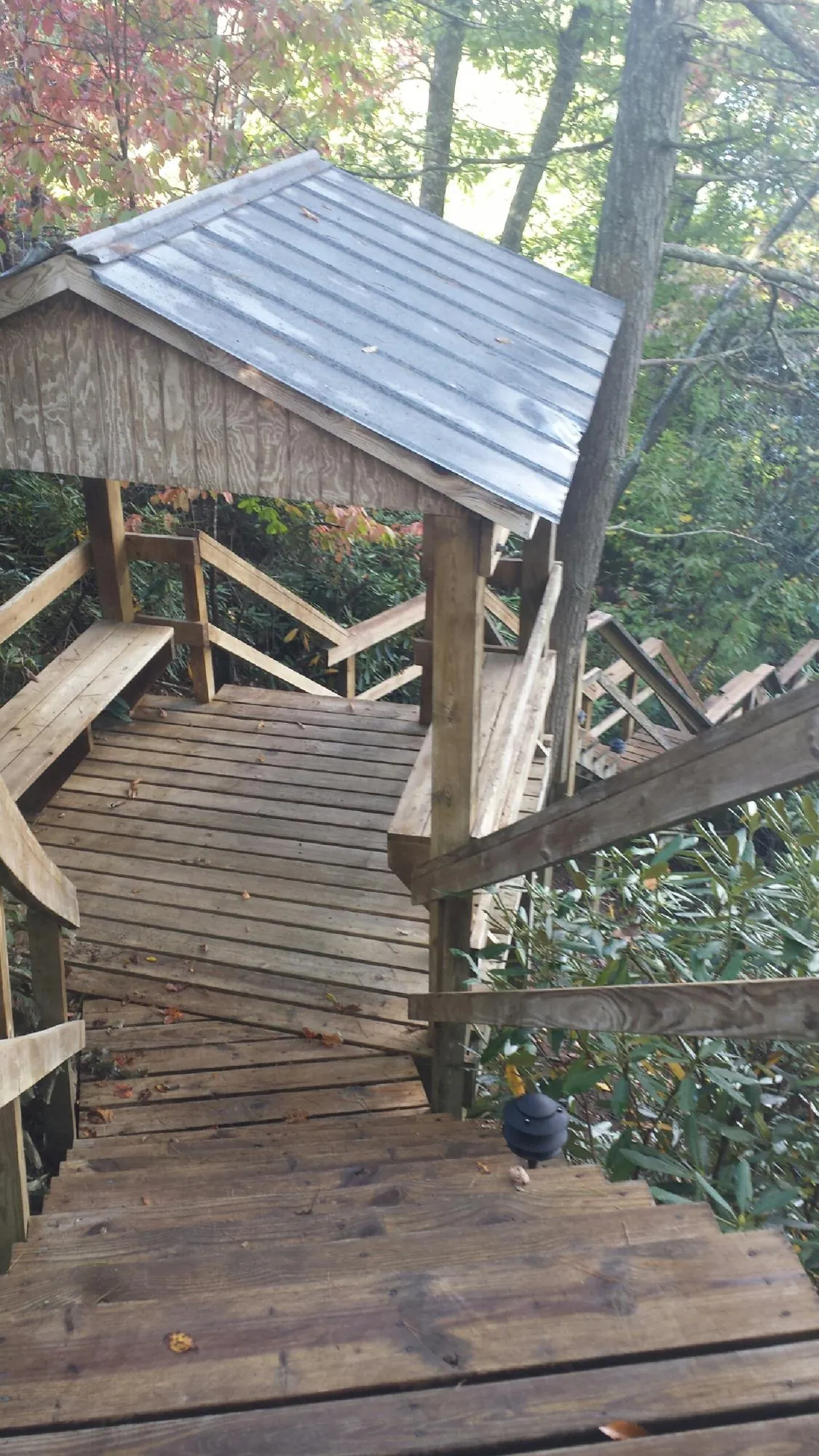 Metal roofed shelter over wooden steps on a wooded walkway — Skylight Repair & Installation work by our crew in Madill