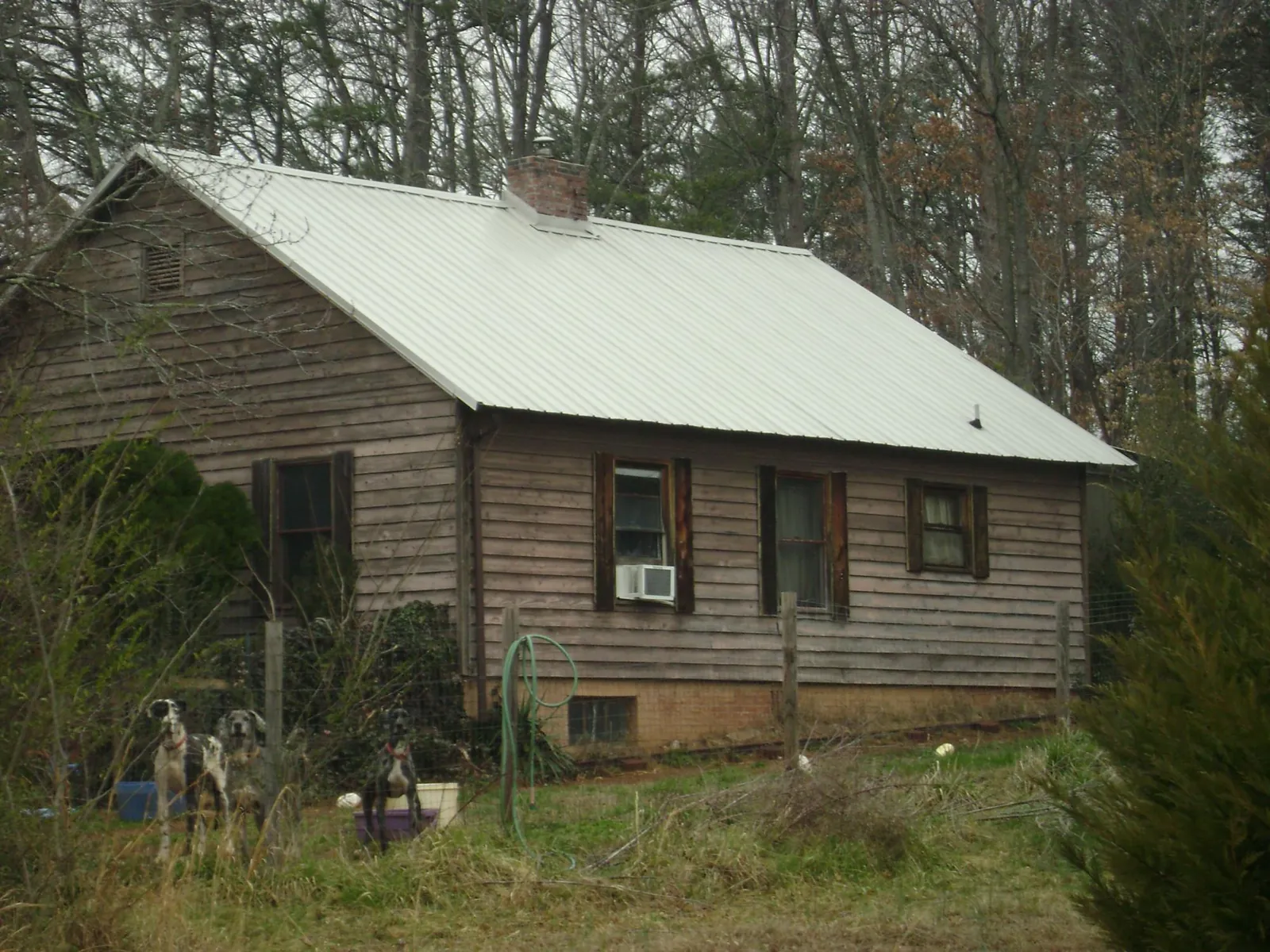 White metal roof on an old wood sided farmhouse, from a Metal Roof Installation job in Madill